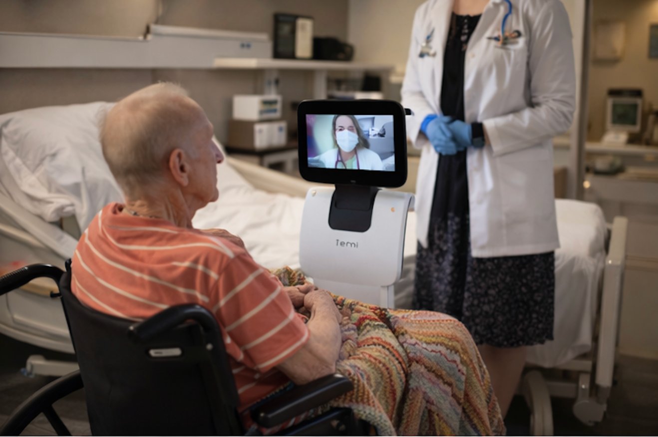 Patient consulting physician on robot screen with nurse present