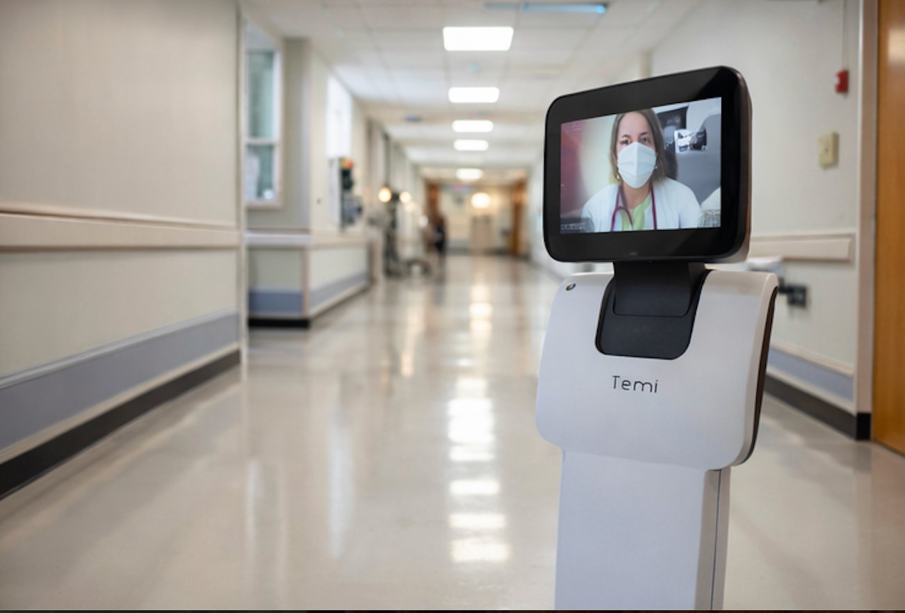 Temi telepresence robot with physician on screen in a facility hallway